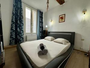 a bedroom with a bed with towels on it at Le Refuge du Coquelicot in Béziers