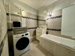 a bathroom with a washing machine and a tub at Le Refuge du Coquelicot in Béziers +12 photos