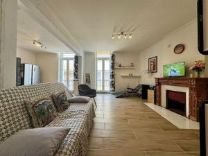 a living room with a couch and a fireplace at Le Refuge du Coquelicot in Béziers
