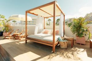a canopy bed on top of a balcony at Iberostar Selection Sábila - Adults Only in Adeje