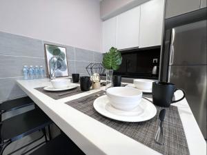 a kitchen counter with bowls and plates on it at BELLSUITE SEPANG NEAR KLIA Airport in Sepang