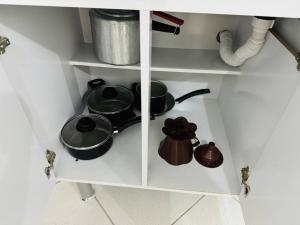a shelf with pots and pans in a kitchen at Kitnet cheia de estilo, ipatinga mg in Ipatinga
