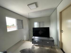 a living room with a flat screen tv in a mirror at Comfort and Style Master Ebony I in Cuiabá