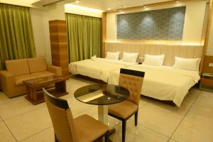 a hotel room with a bed and a table and chairs at Hotel Parqotel in Arnāla +19 photos