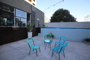 three blue chairs and a table on a patio at DFC by FMA Coliving in Salta