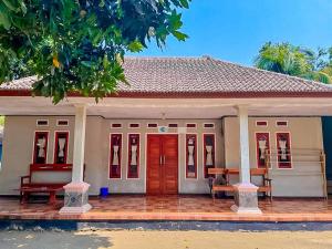 a small house with red doors and benches in front at Penginapan,Villa dan Homestay Geopark Ciletuh in Cilowa
