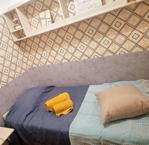 a bed with a yellow towel and a pillow on it at Casa dos pais in Crato
