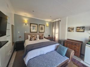 约翰内斯堡B&B on Buckingham Guest House的带一张大床和一张沙发的卧室