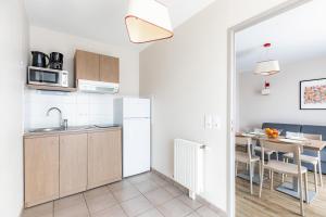 a kitchen and dining room with a table in a room at Appart'City Confort Orléans in Orléans