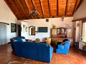 a living room with two blue couches and a tv at Cabañas Huerta la Mision, Zacatlán in Zacatlán