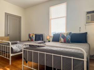 a bedroom with two beds and a window at Must See Pittsburgh Mansion 10 Bedrooms 20 Beds in Duquesne