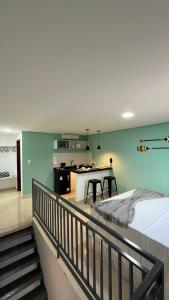a bedroom with a bed and a kitchen with a counter at Pousada Vila Caetité Lofts in Caetité