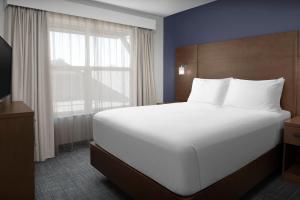 a bedroom with a large white bed and a window at Residence Inn Bozeman in Bozeman
