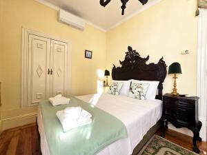a bedroom with a large bed with white sheets at Quinta da Malafaya in Nogueira