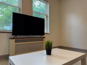 a living room with a flat screen tv on a wall at Must See Pittsburgh Mansion 10 Bedrooms 20 Beds in Duquesne