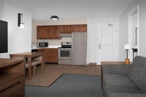 a kitchen with a white refrigerator and a table at Residence Inn Bozeman in Bozeman
