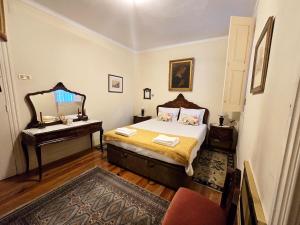 a bedroom with a bed with a mirror and a piano at Quinta da Malafaya in Nogueira