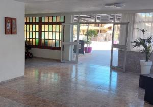 an empty lobby with an open door and potted plants at Estudio en Torres del Sol en lado del mar in Arona +38 photos