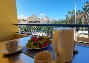 a table with a plate of fruit on a balcony at Estudio en Torres del Sol en lado del mar in Arona