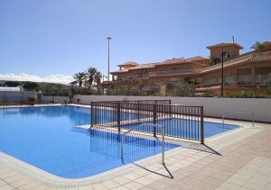 a swimming pool with a fence around it at Estudio en Torres del Sol en lado del mar in Arona