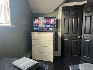 a bedroom with a flat screen tv on a dresser at Beautiful Country Home 7 Beds Sleeps 9 in Johnstown