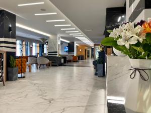 een lobby met een vaas met bloemen op een toonbank bij SPA Hotel Olymp in Velingrad