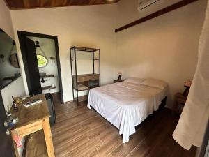 a bedroom with a white bed and a mirror at Pousada Villa Tropea - Fazenda Chapadão in Serra Negra