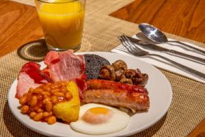 a plate of breakfast food with eggs bacon beans and meat at Britannia Hotel Newcastle Airport in Newcastle upon Tyne