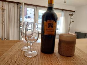 a bottle of wine and two wine glasses on a table at Sky Haus Residence inkl parking in Täsch