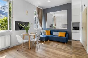 a living room with a blue couch and a table at Central Station stylish studio in Warsaw