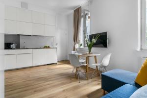 a living room with a table and a blue couch at Central Station stylish studio in Warsaw +7 photos