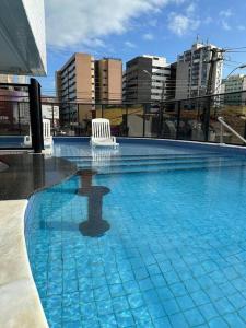 マセイオにあるApartamento Agradávelの街中の白い椅子が置かれた大きなプール