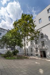 a tree in front of a building with a bench at Central Station stylish studio in Warsaw