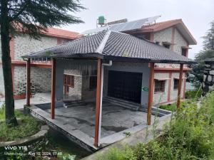 a house with a solar roof on top of it at Durgadevi Guesthouse by StayApart in Rudraprayāg +9 photos