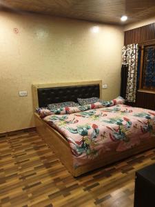 a bedroom with a bed in a room with wooden floors at New mehdudia B&B in Shimla