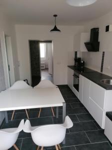 a kitchen with a white table and white chairs at Ferienwohnung II Sarrebriese in Bottmersdorf