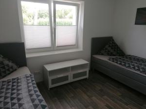 a small bedroom with two beds and a window at Ferienwohnung II Sarrebriese in Bottmersdorf