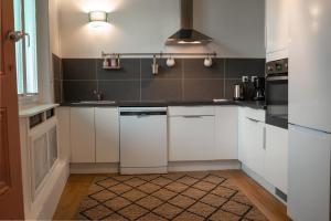 a kitchen with white cabinets and a stove top oven at Le Dada 6 personnes hypercentre Epernay in Épernay