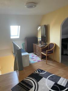 a living room with a desk and a chair at Familie Alber 1P in Elze