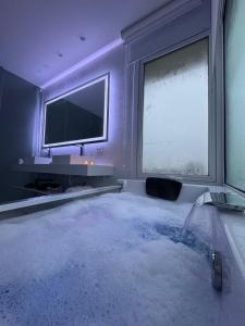 ein Zimmer mit Badewanne mit Fernseher und Fernseher in der Unterkunft Serena Boutique Potrero Garay in Potrero de Garay