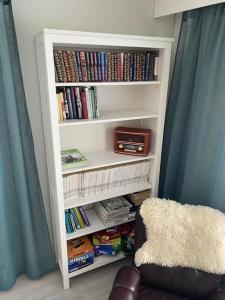 a book shelf filled with books and a radio at Paritalon huoneisto in Raahe
