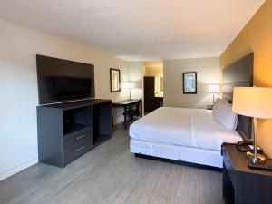 a hotel room with a bed and a flat screen tv at Motel 6 Charlotte, NC Northlake in Charlotte