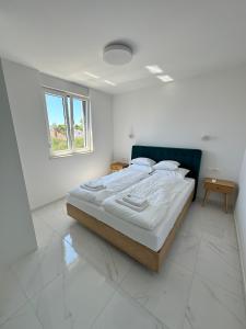a bedroom with a large bed in a white room at Beautiful new PalmTree Apartments in Vir
