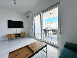 a living room with a flat screen tv and a table at Beautiful new PalmTree Apartments in Vir