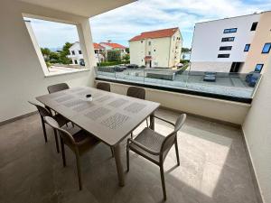 a table and chairs on a balcony with a view at Beautiful new PalmTree Apartments in Vir