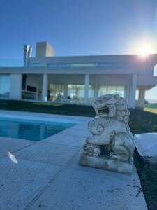 eine steinerne Löwenstatue, die neben einem Pool sitzt in der Unterkunft Serena Boutique Potrero Garay in Potrero de Garay