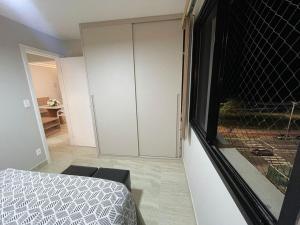 a bedroom with a bed and a sliding glass door at Apto de frente ao mar da Praia de Itaparica ES in Itaparica