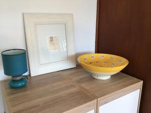a yellow bowl on a wooden dresser with a mirror at Deux grandes chambres en rez-de-jardin in Montayral +7 photos