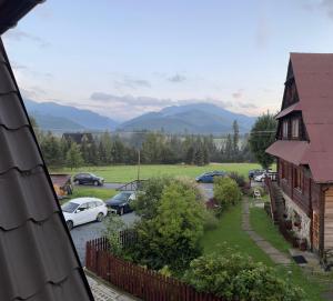 Blick von einem Haus mit auf einem Parkplatz geparkten Autos in der Unterkunft Pokoje u Sarnowskich in Kościelisko