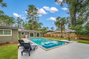 a swimming pool with two chairs and a house at The Monterey -- Private Pool & Grill - 4 KING Beds in Gainesville